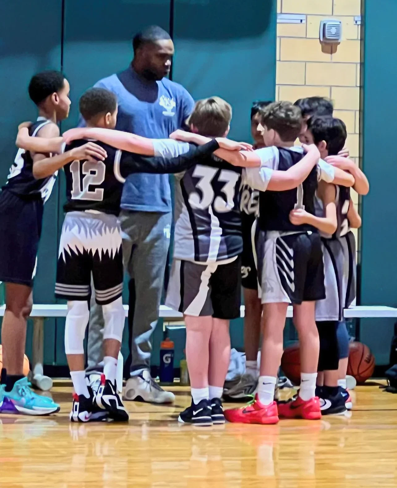 Pro Reps players and a coach in a team huddle